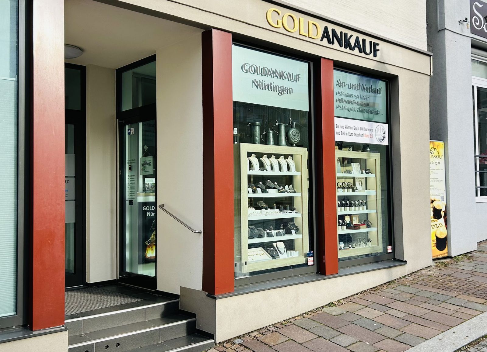 Der Laden von Goldankauf Nürtingen schräg von der Gasse aus, mit Eingang, Stufen und Kopfsteinpflaster